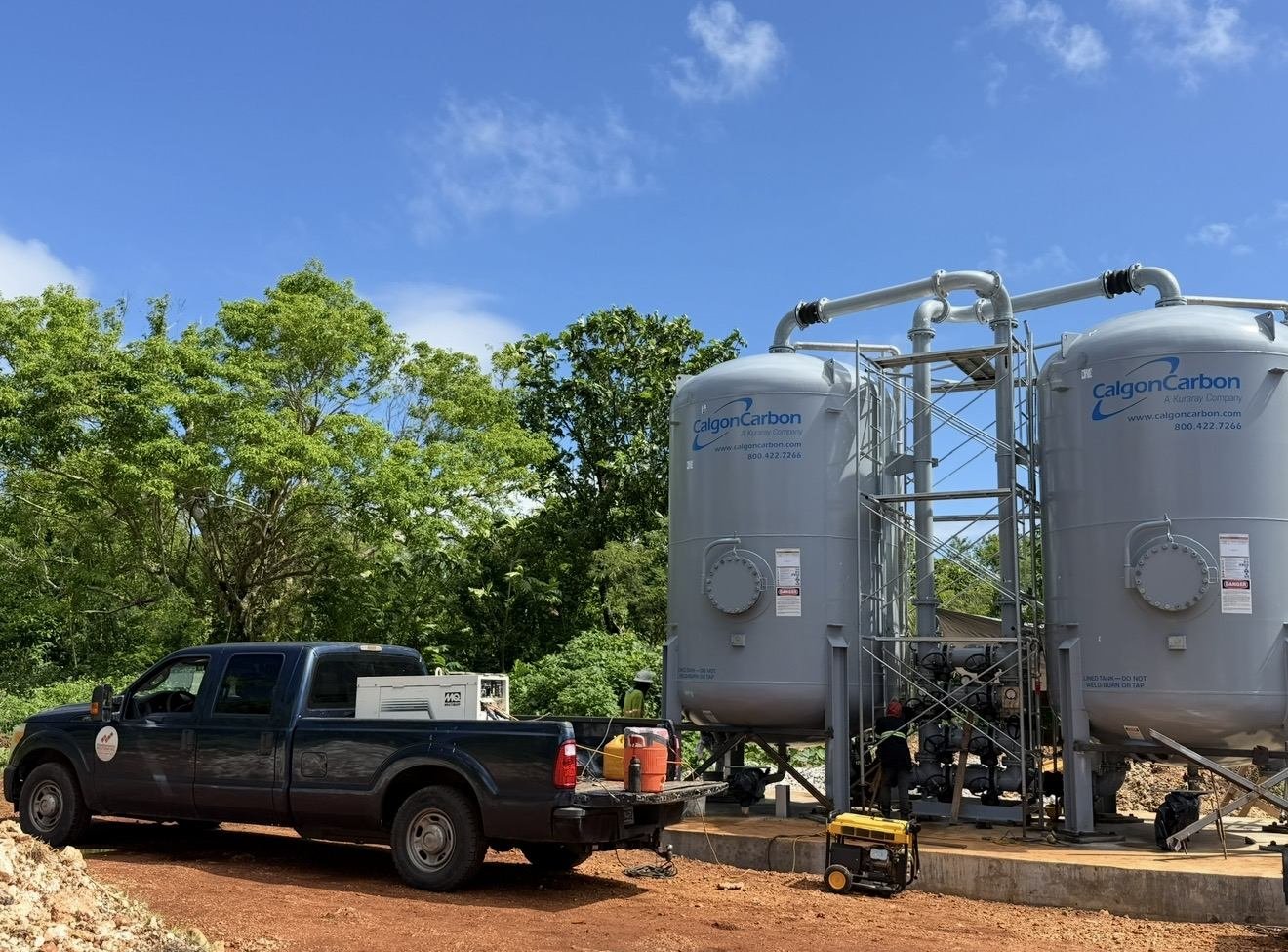 Row of grey water treatment filter vessels with a company pickup truck