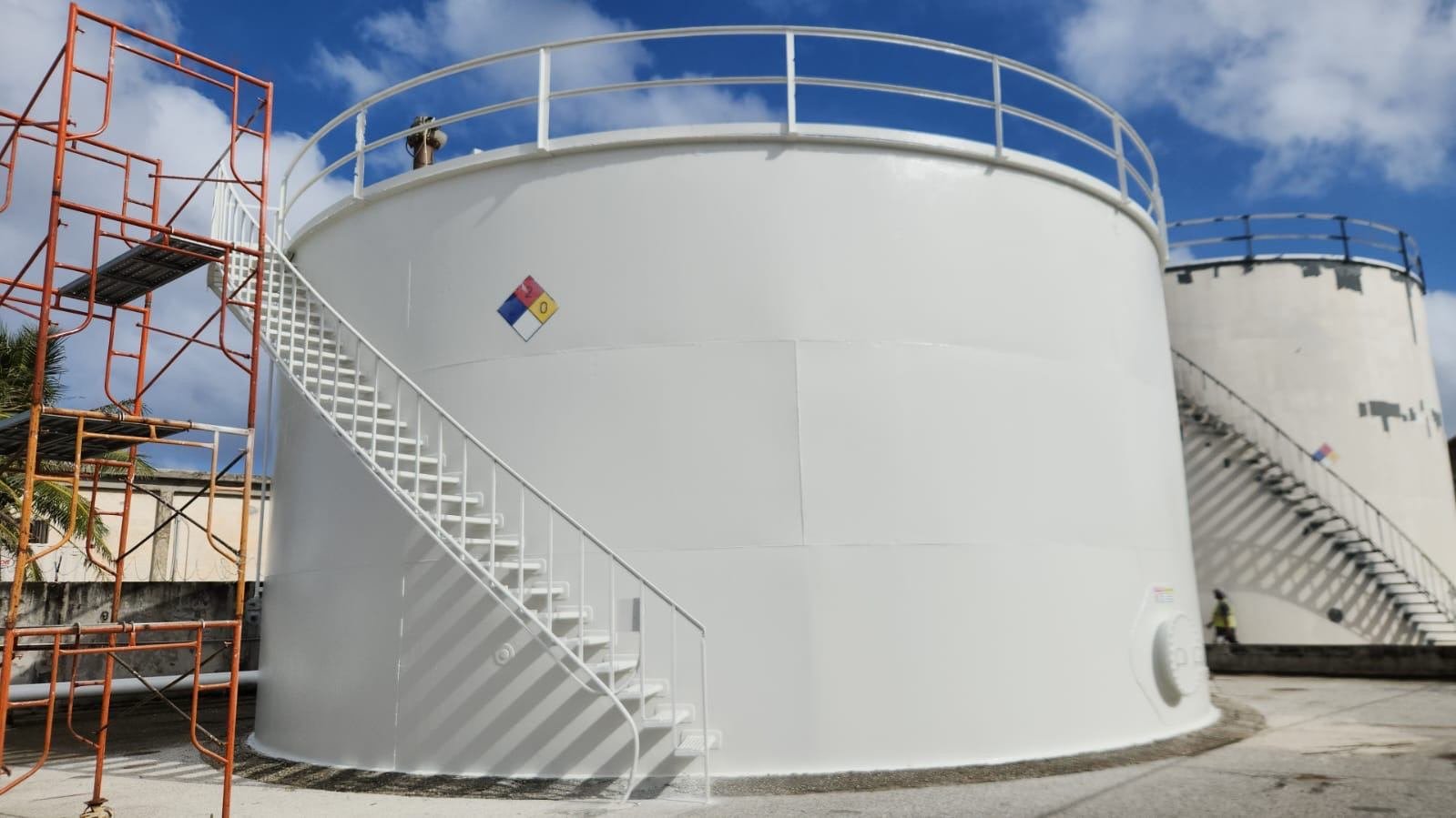 Freshly painted white fuel storage tank with stairway and scaffolding