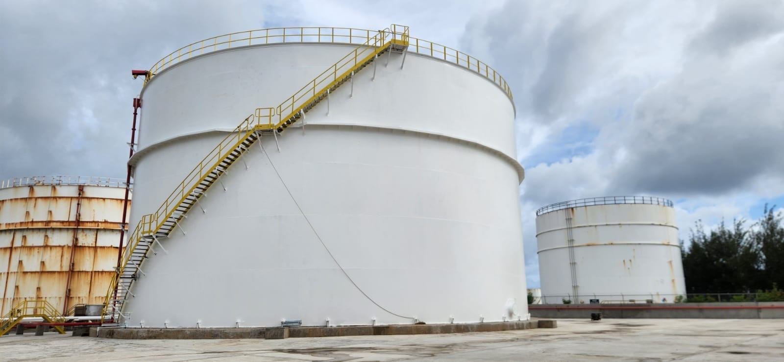 Large white fuel storage tank with stairway after repainting