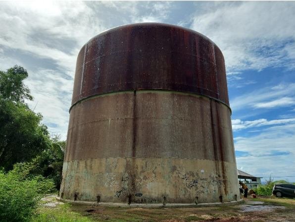 Pigua tank in Merizo before repair, rust-brown shell